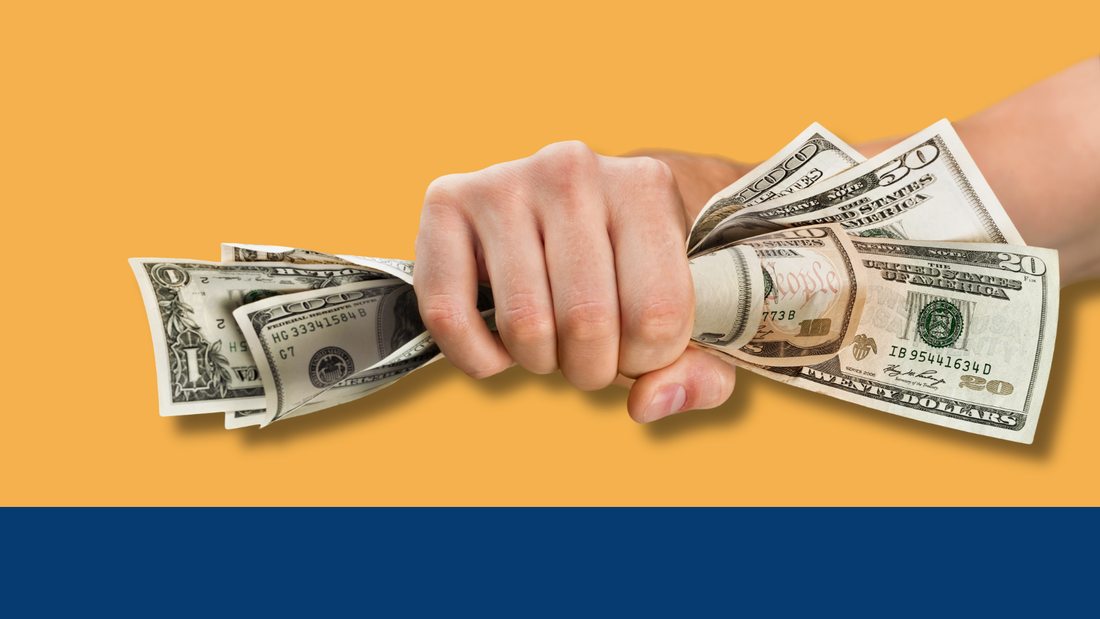 A hand gripping a fistful of cash